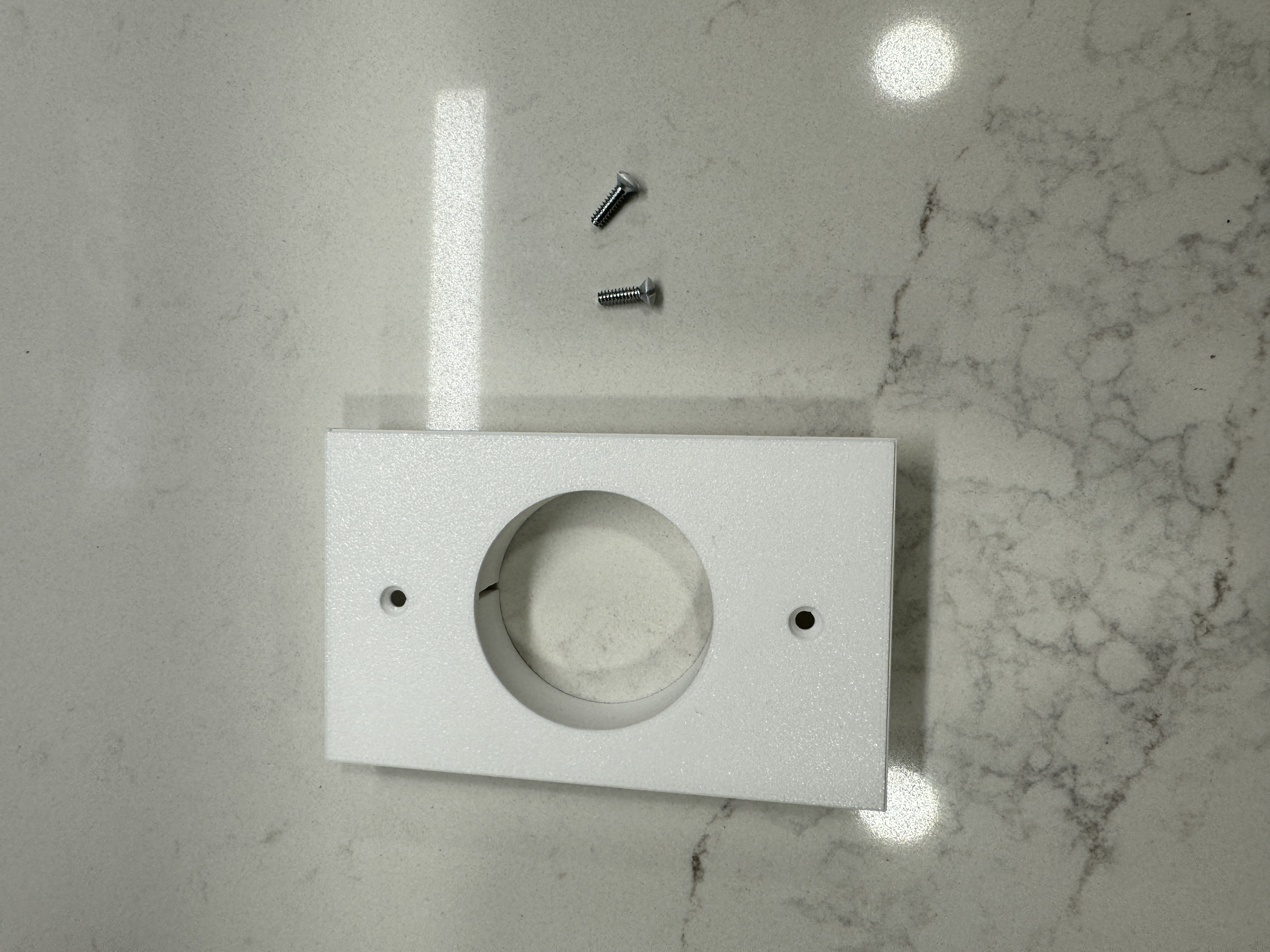 Camera bracket comes assembled with 2 white plate screws to cover up the holes with a matching color screw to the face plate